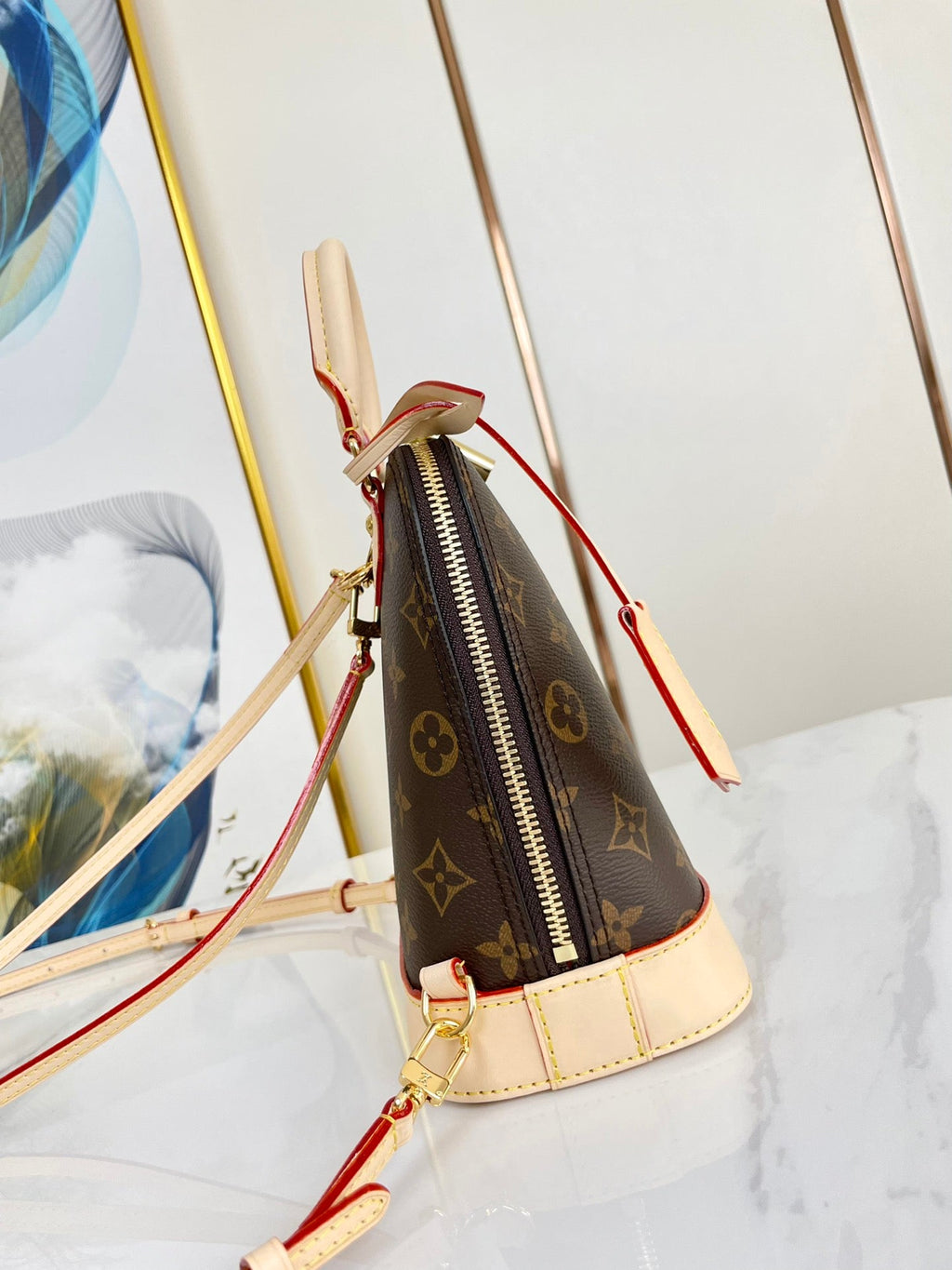 ALMA RUCKSACK 20 IN BRAUNEM MONOGRAMM-CANVAS UND BEIGEM KALBSLEDERBESATZ MIT GOLDENER SCHNALLE