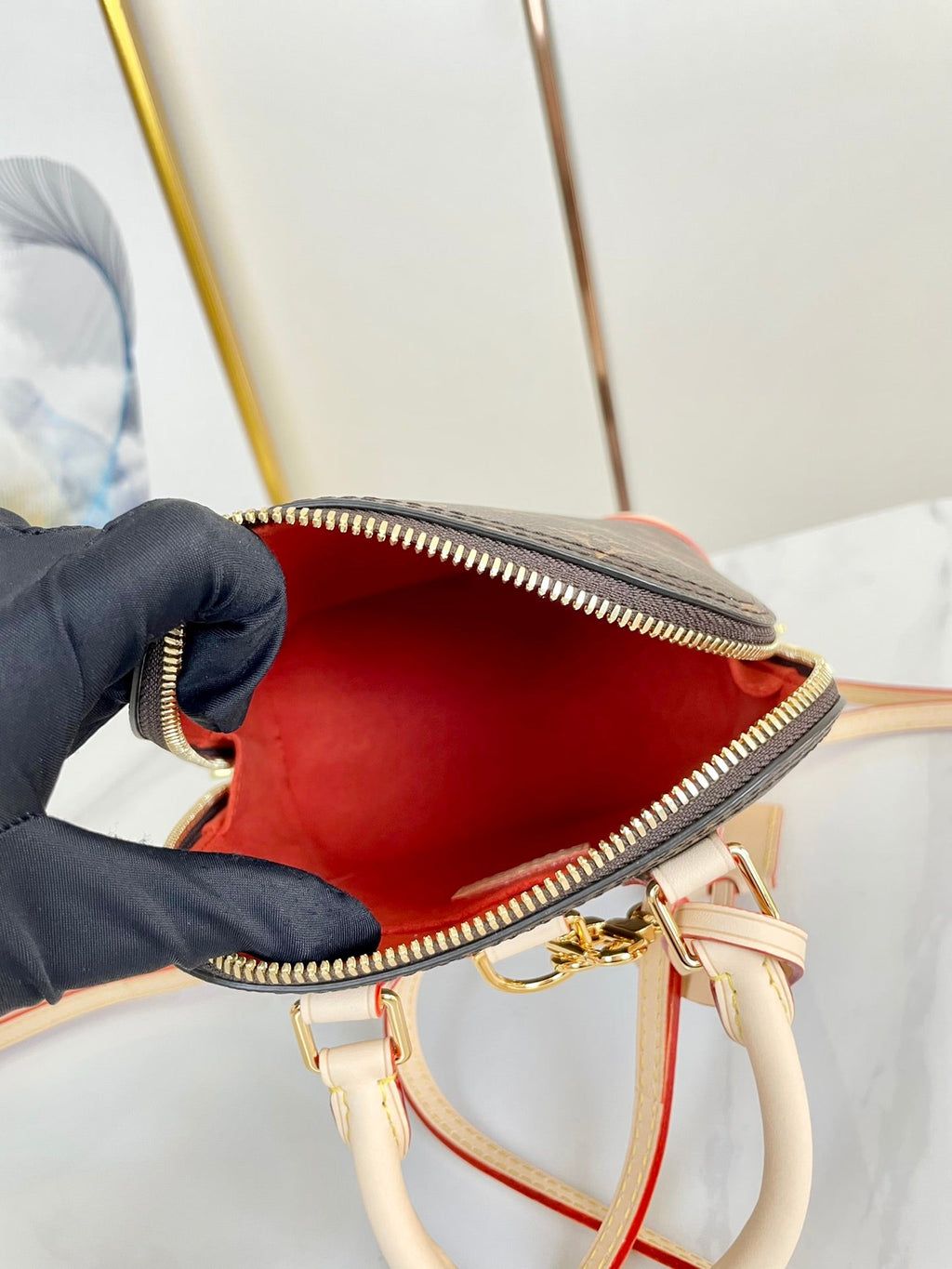 ALMA RUCKSACK 20 IN BRAUNEM MONOGRAMM-CANVAS UND BEIGEM KALBSLEDERBESATZ MIT GOLDENER SCHNALLE