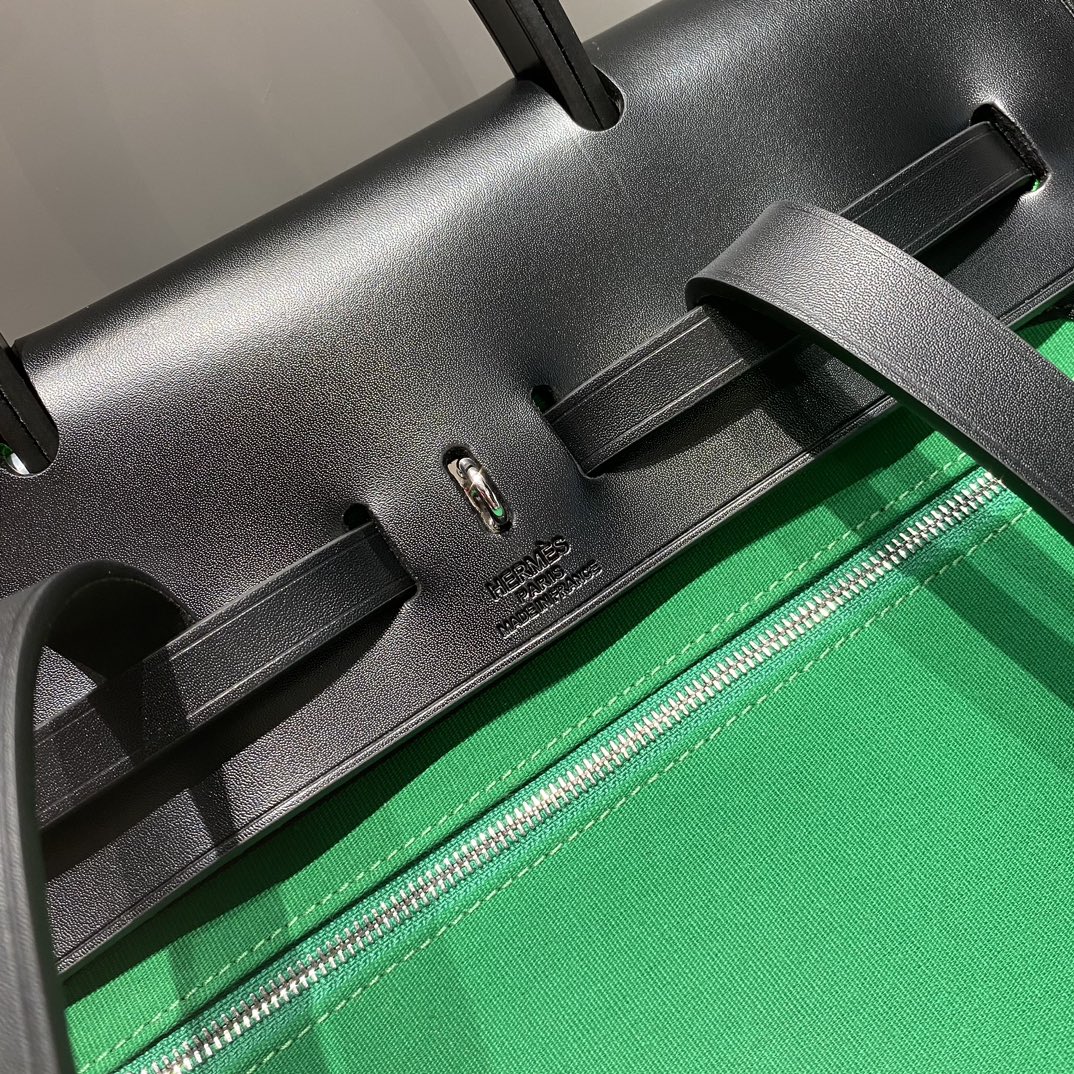 HERBAG A DOS ZIP RETOURNE BACKPACK 29 IN GREEN CANVAS AND BLACK CALFSKIN