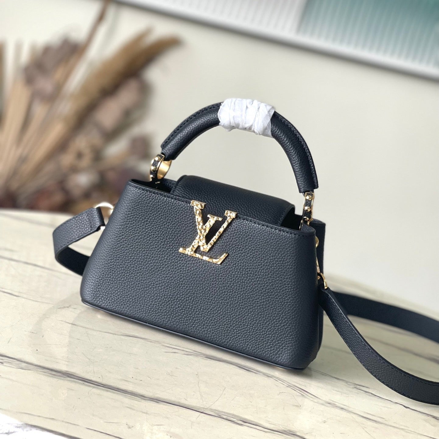 CAPUCINES EAST-WEST MINI 22 IN SCHWARZEM KALBSLEDER GOLDENE HARDWARE